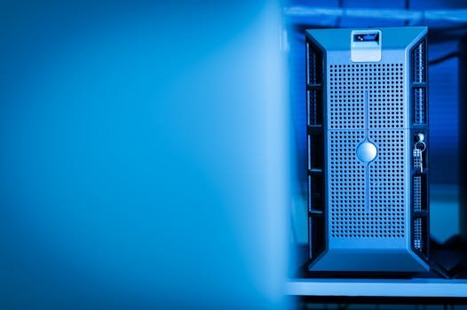 Close-up of a modern server unit in a blue-lit data center environment.